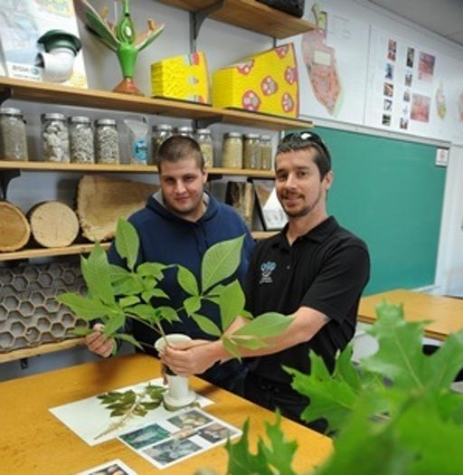 植物科学与景观技术教授吉姆船井(左)与一名学生一起研究植物鉴定
